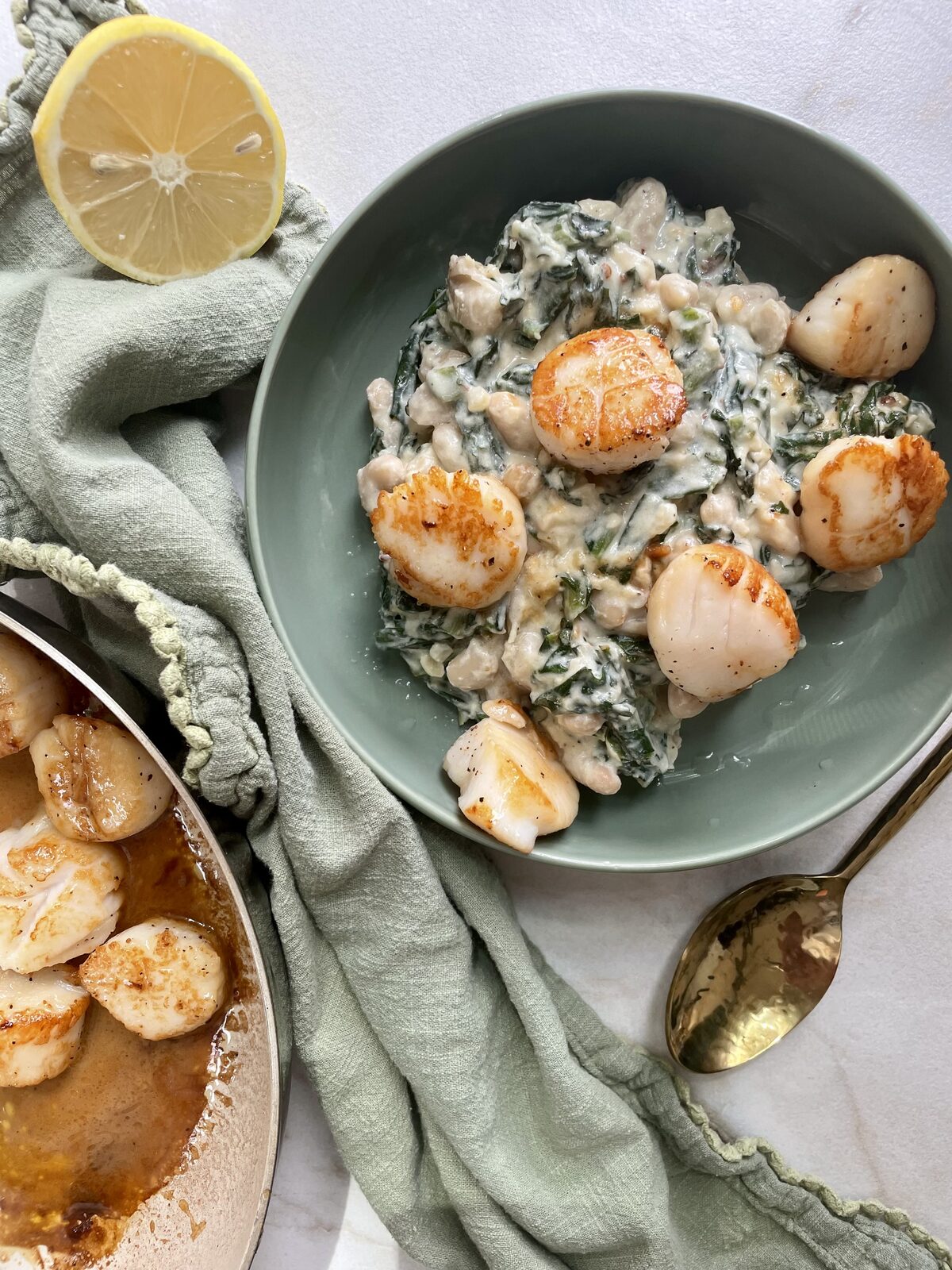 Seared scallops over creamy dandelion greens with white beans